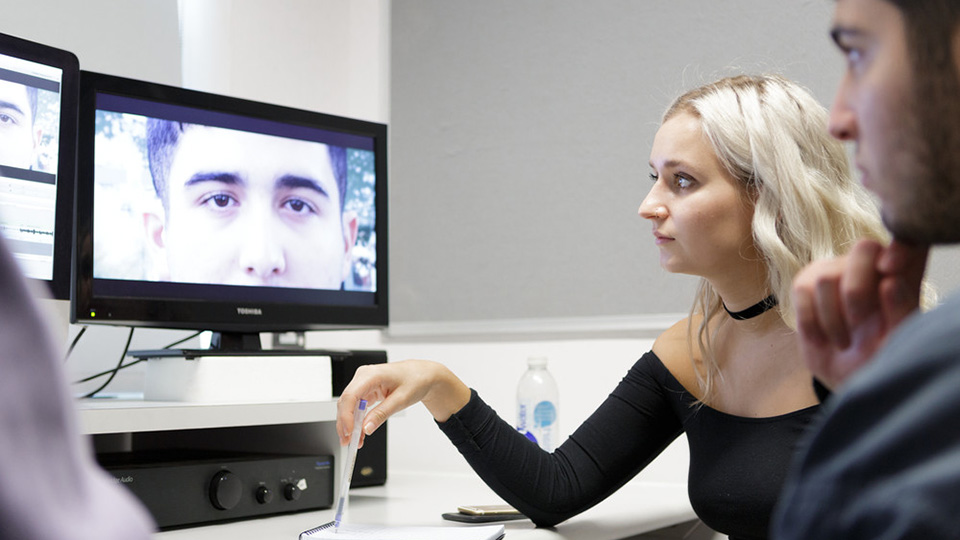 Students watching back a film edit in an edit suite